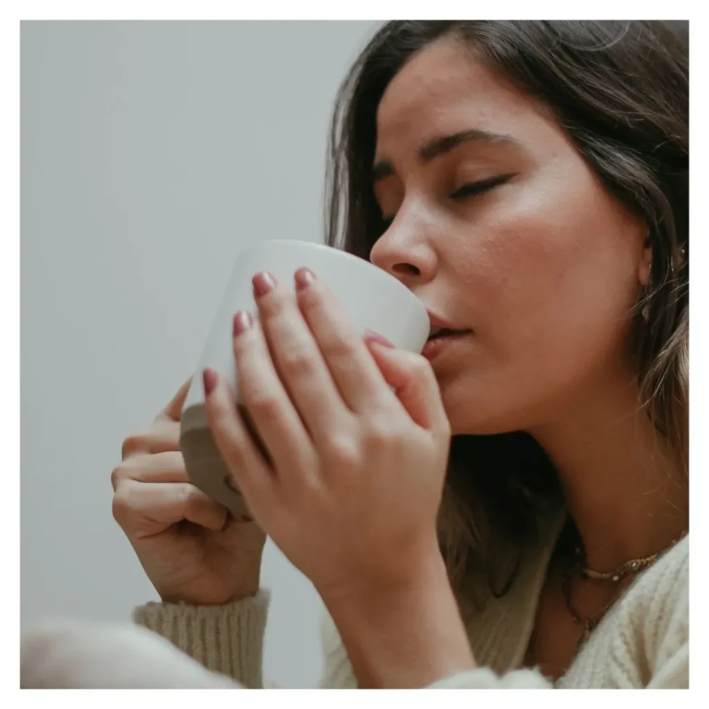 girl with eyes closed sipping chai