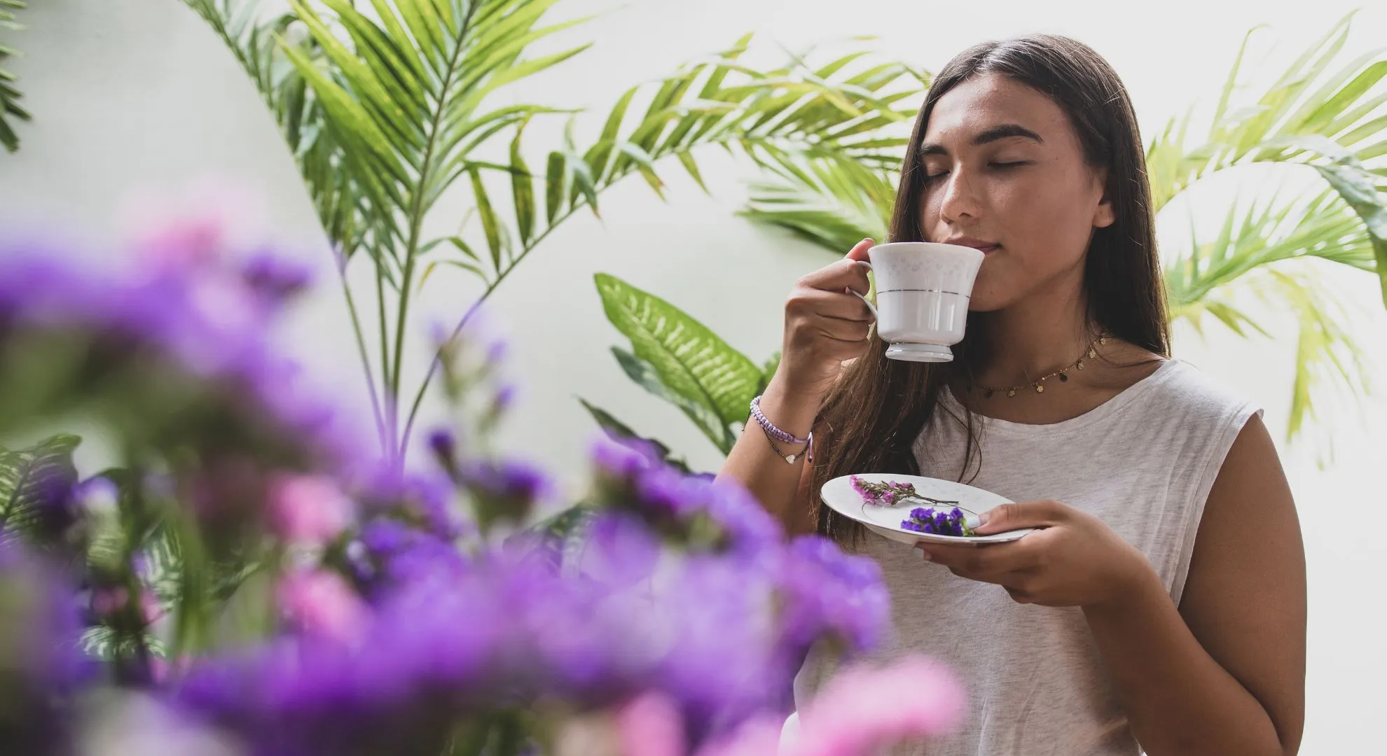 woman drinking tea framed by flowers