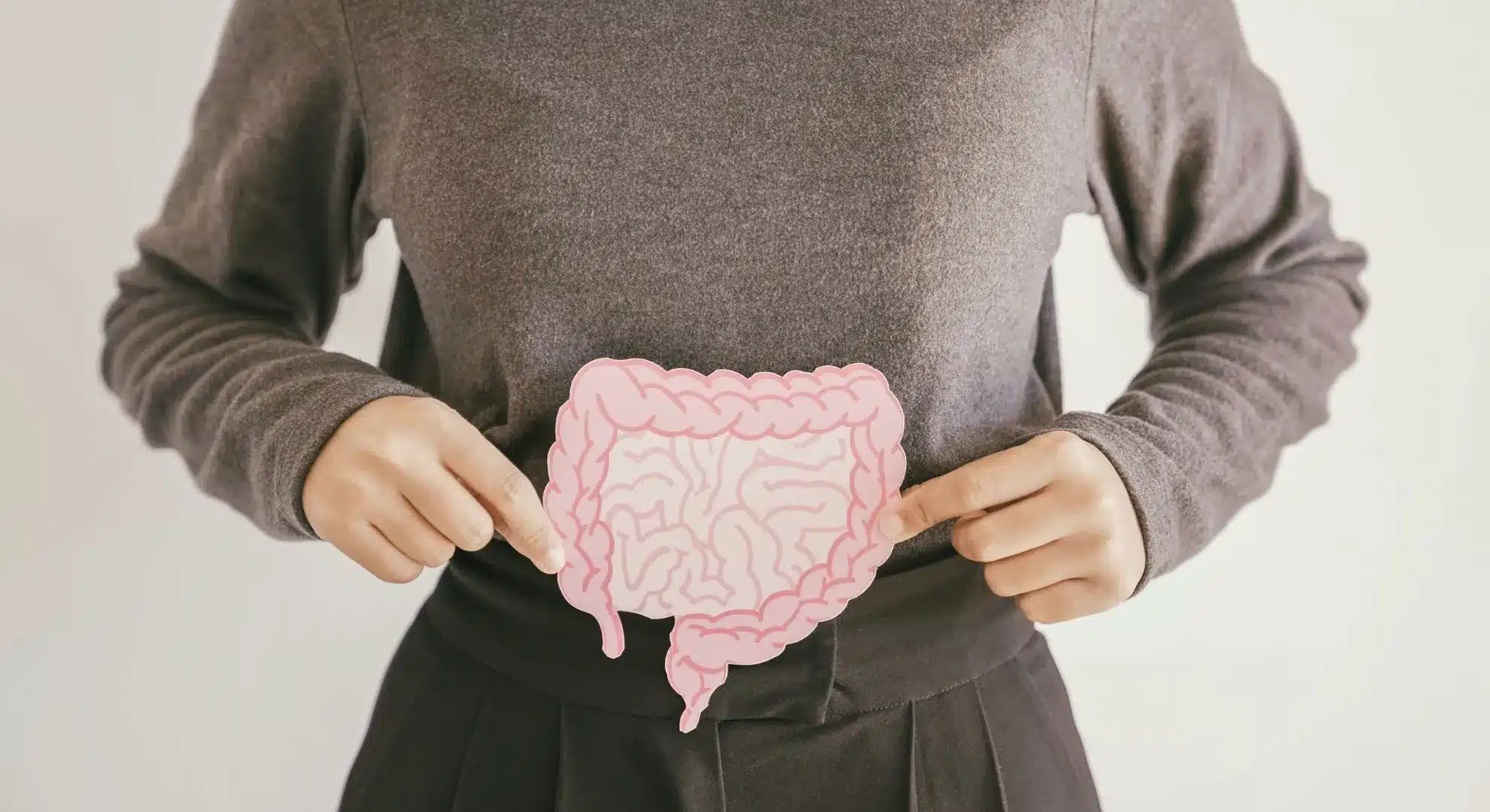 woman holding paper printout of intestines against her stomach